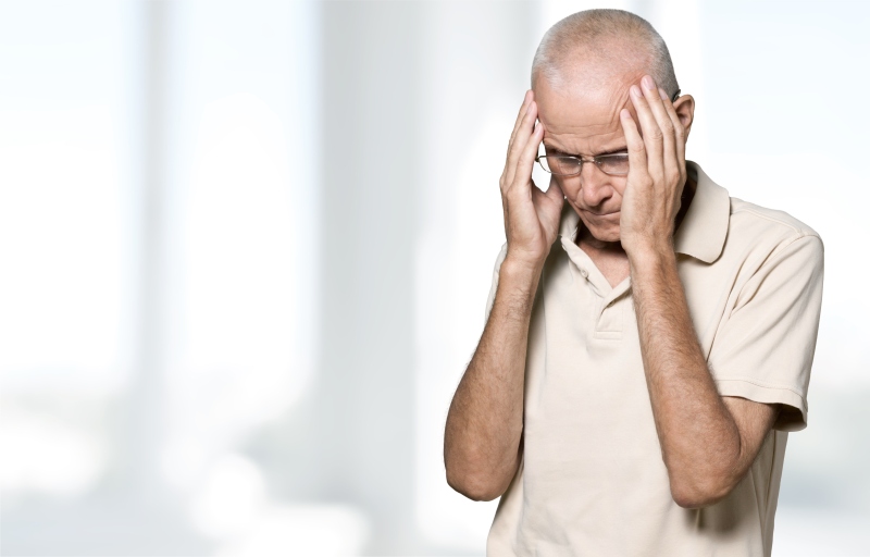 Mann hält sich beide Hände an die Schläfen