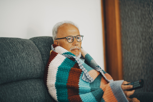 Alter Mann in Decke gewicket auf dem Sofa.