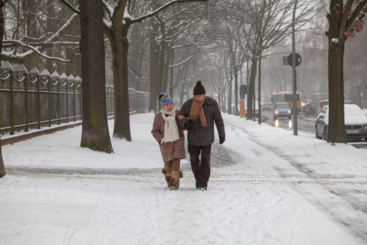 Altes Senioren Paar geht im Schnee spazieren