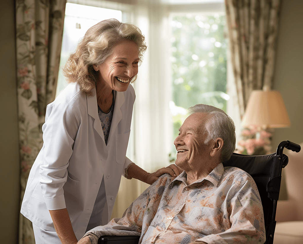 Älterer Herr im Rollstuhl. Neben ihm steht eine Betreuungsassistentin, die sich zu ihm runterlehnt und lächelt.