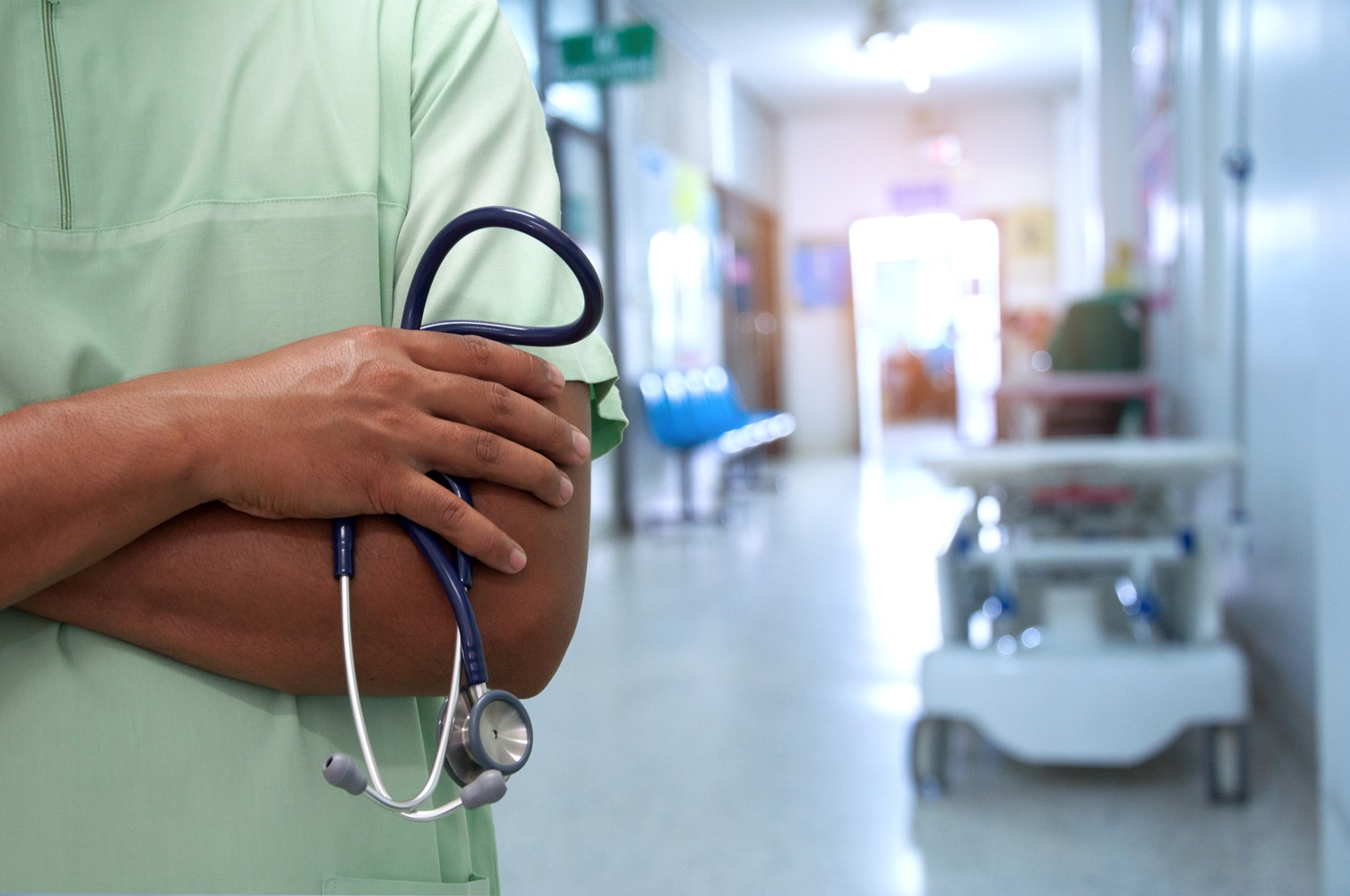 Person im grünen Kasack mit Stethoskop