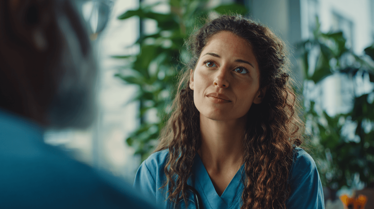 Frau mit langen brauen Locken, schaut traurig, aber gefasst auf ihren Gesprächspartner. Symbol für Abmahnungsgespräch