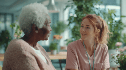 Junge rothaarige Pflegerin mit aufgeschlossenem Blick bei Seniorin im Heim_symbol probezeit