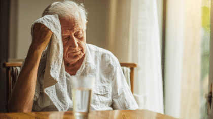 Seniorer Mann wischt sich mit Tuch die Stirn