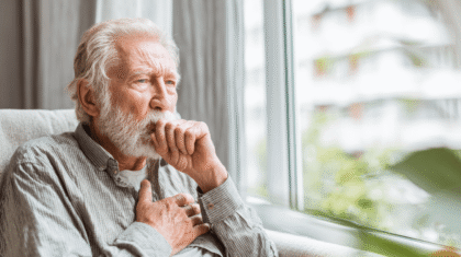 Hustender Mannhält sich die Hand vor die Brust, Symbol für COPD