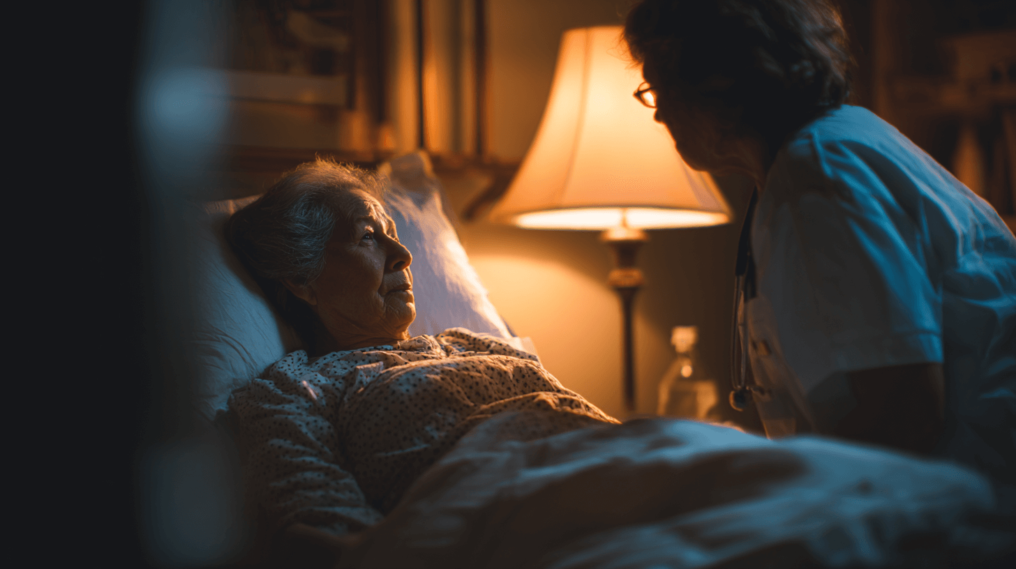 Pflegeperson bei Seniorin, die liegend im Bett ist, Symbolbild für Nachtpflege im ambulanten Bereich
