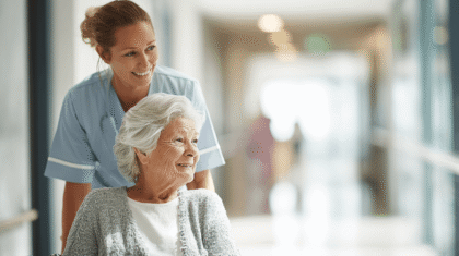 Pflegeperson schiebt Patientin in Rollstuhl, Symbol für Nähe und Distanz