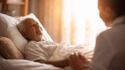 Mann liegt im Bett und läschelt erschöpft, Symbolbild für Palliativpflege