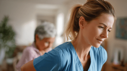 Pflegeperson in blauem Kasack mit Rückenschmerzen