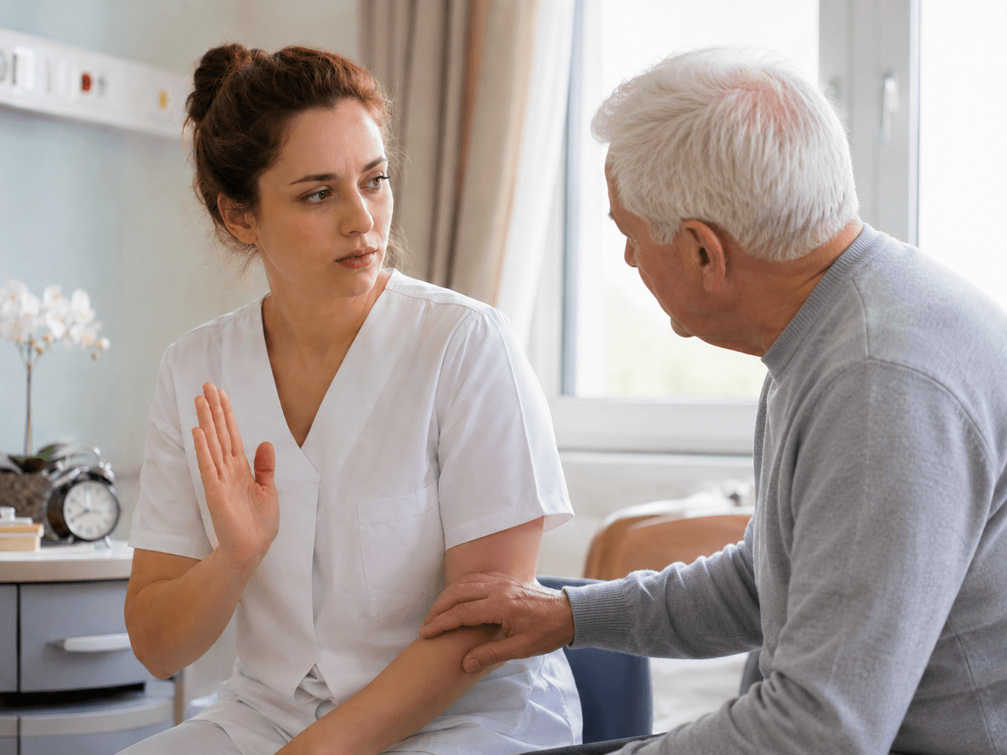 Junge Pflegekraft macht ein Stopp-Zeichen mit der Hand, während ein älterer Herr sie am Arm berührt.
